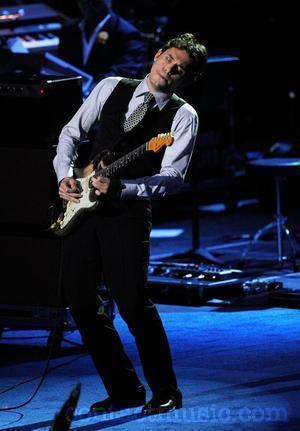 John Mayer on stage playing guitar