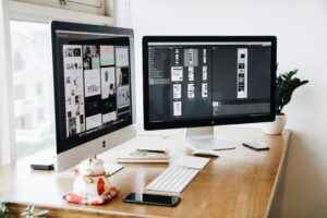 website design consultations discuss key business topics image shows two monitors on desk 