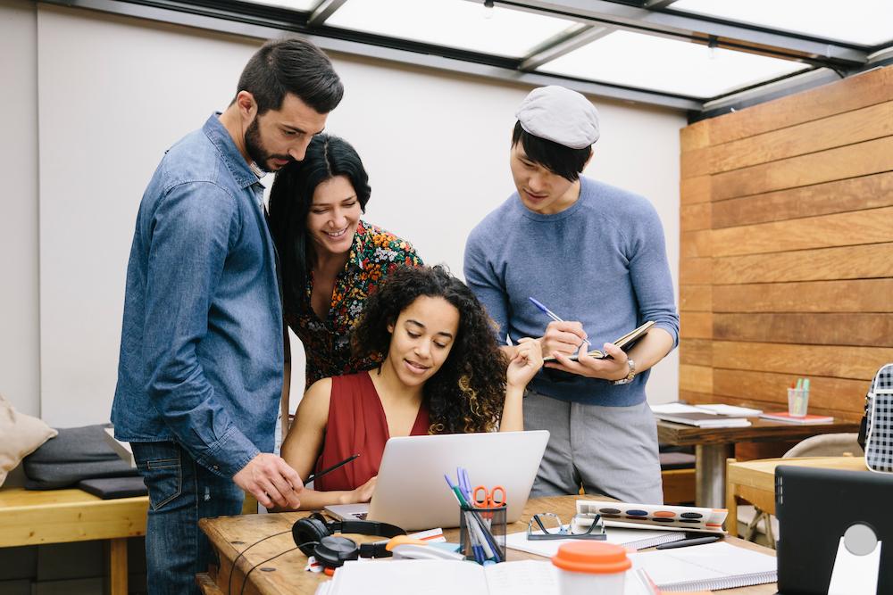 Consistent business website redesigns help with user experience and security image shows group of people looking at laptop