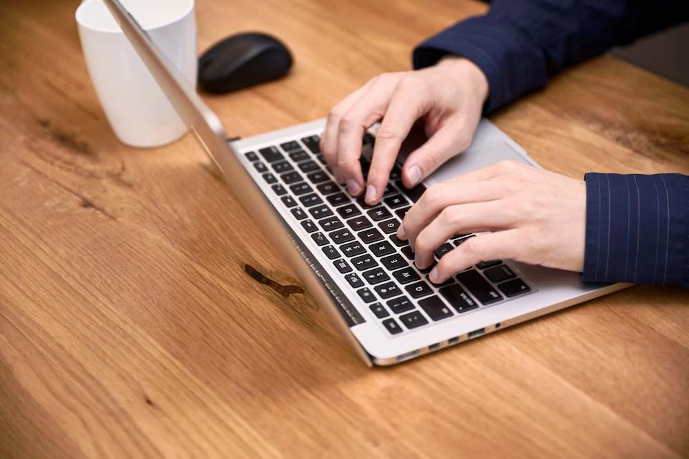 businesses should monitor current website design trends image shows hands typing on laptop